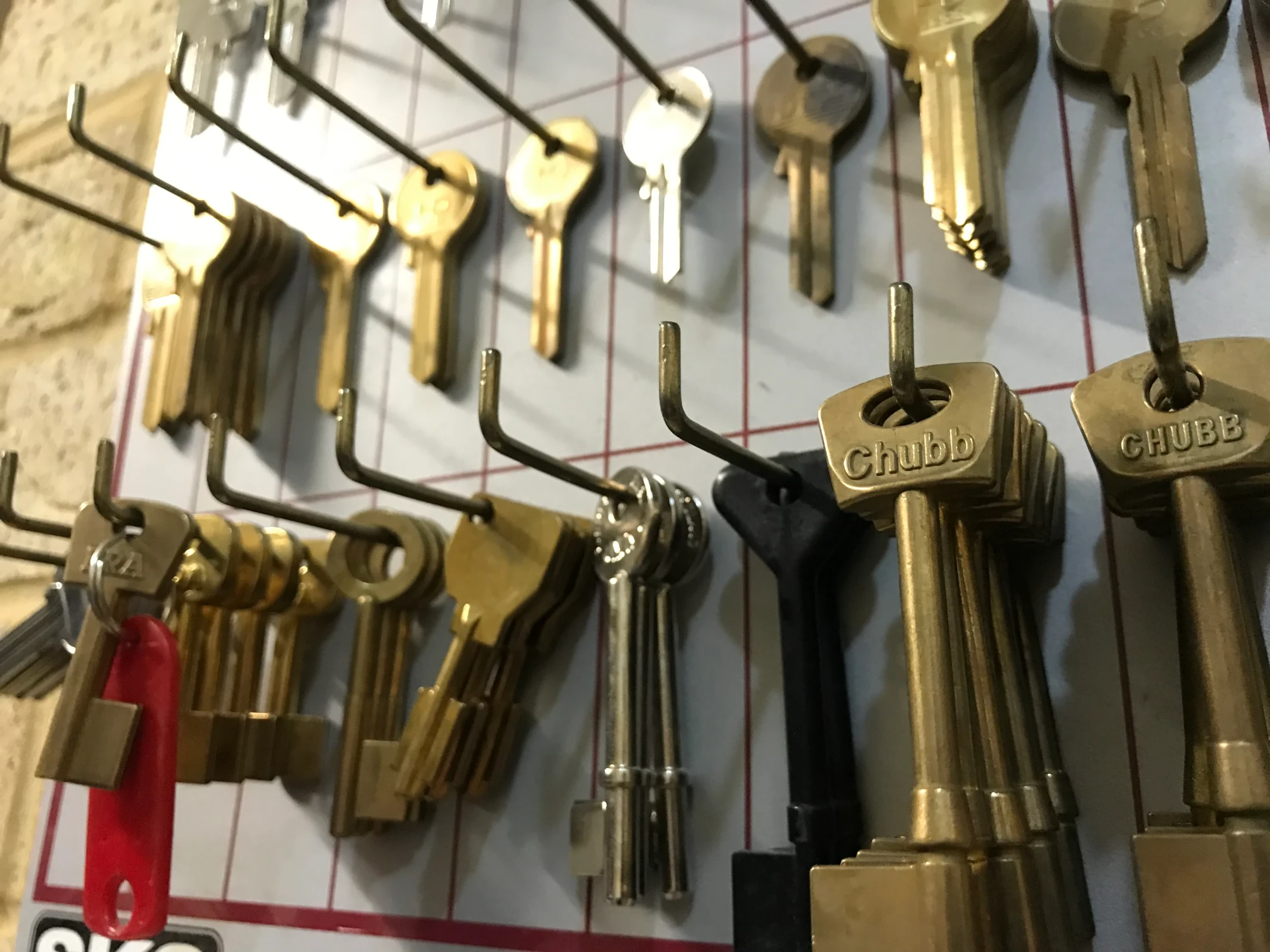 Wide selection of key blanks hanging on hooks, used for duplicating keys.